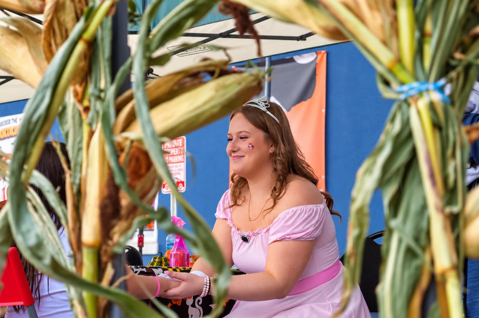 A princess smile, framed by autumn cornstalks.