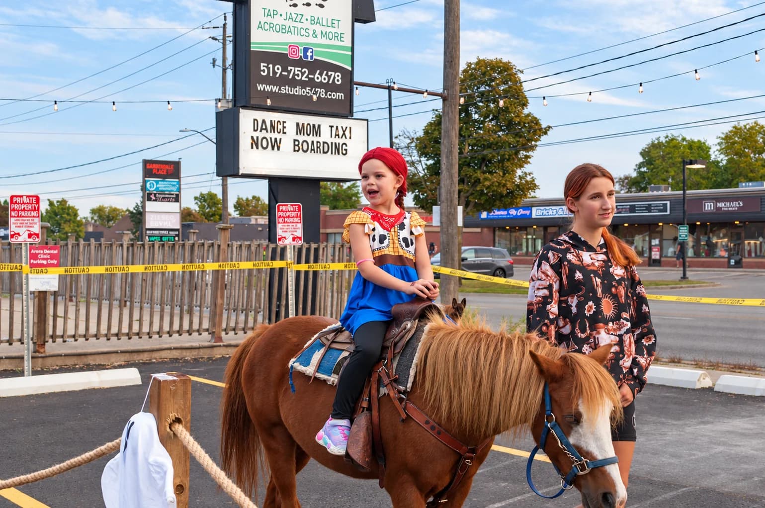 A cowgirl enjoys a pony ride.